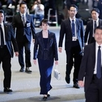 　皇居での任命式と認証式のため、首相官邸を出る高市早苗首相（中央）＝２１日午後６時１８分