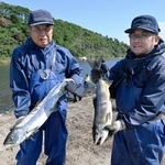 　今季初となる漁で取れたサケを持つ木戸川漁協の組合員ら＝２３日午前、福島県楢葉町の木戸川