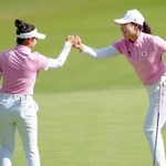 　第２ラウンド、１１番でバーディーを奪い、タッチを交わす山下美夢有（左）と竹田麗央＝新朝鮮ＣＣ（共同）