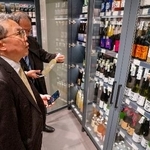 　ウクライナ・キーウのスーパーに陳列された日本酒を見る日本の代表団のメンバー＝２８日（共同）