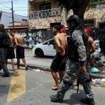 　２８日、ブラジル・リオデジャネイロで、警察に拘束された犯罪組織のメンバー（ロイター＝共同）