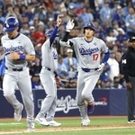 　ワールドシリーズ第１戦の７回、２ランを放ち三塁コーチとタッチを交わすドジャース・大谷（右）＝２４日、トロント