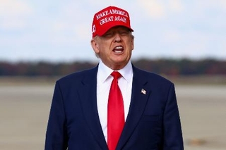 　「米国を再び偉大に」のロゴが入った帽子をかぶるトランプ大統領＝１０月３０日、ワシントン郊外のアンドルーズ空軍基地（ロイター＝共同）