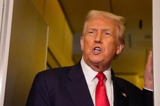 　１０月３０日、米大統領専用機内で記者団に話すトランプ米大統領（ゲッティ＝共同）