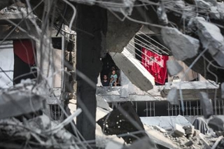 　イスラエル軍による停戦後の攻撃でがれきと化した建物の中で暮らすパレスチナ人家族＝３日、ガザ北部ガザ市（ゲッティ＝共同）