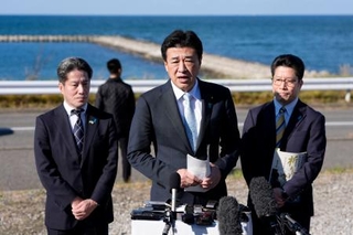 　横田めぐみさんが北朝鮮工作員に拉致されたとみられる現場周辺を視察し、記者団の取材に応じる木原官房長官。めぐみさんの弟拓也さん（右）と哲也さん（左）も同行した＝１５日午後、新潟市