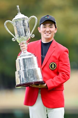 　通算１７アンダーで優勝し、トロフィーを手に笑顔の金子駆大＝太平洋クラブ御殿場