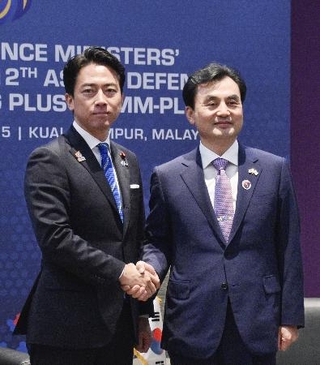 　会談で握手する小泉防衛相（左）と韓国の安圭伯国防相＝１日、クアラルンプール（共同）