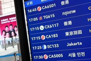 　北京首都国際空港の出発ロビーで羽田空港行きの便が表示された電光掲示板＝１６日（共同）