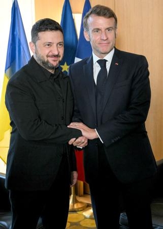 　首脳会談で握手するウクライナのゼレンスキー大統領（左）とフランスのマクロン大統領＝２３日、ブリュッセル（ロイター＝共同）