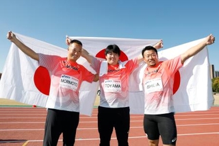 　「東京デフリンピック」の男子ハンマー投げで日本勢が表彰台を独占。日の丸を掲げる金メダルの遠山莉生（中央）、銀メダルの森本真敏（左）、銅メダルの石田考正＝２０日、大井ふ頭中央海浜公園陸上競技場