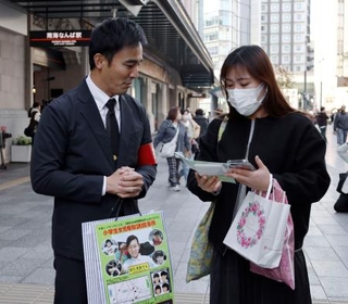 　吉川友梨さんの情報提供を呼びかける大阪府警の警察官（左）＝２０日午後、大阪・難波