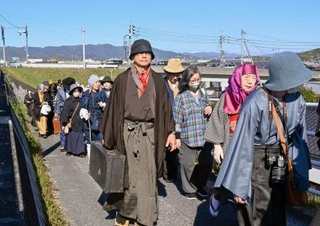 　「１０００人の金田一耕助」と銘打ったイベントで、登場人物に仮装してゆかりの地を練り歩く参加者ら＝２２日午後、岡山県倉敷市