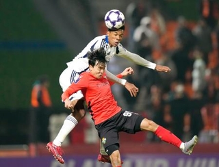 　町田-江原　後半、ヘディングで競り合う町田・望月（上）＝春川（共同）
