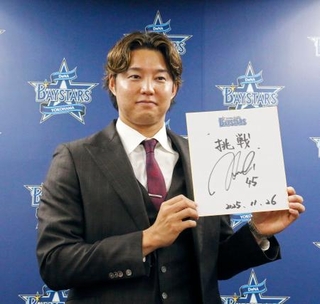 　契約更改交渉を終え、記者会見で抱負を記した色紙を掲げるＤｅＮＡの森原＝２６日、横浜市の球団事務所
