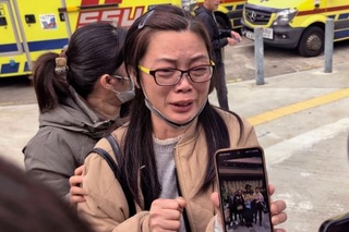 　火災が起きた高層住宅で一緒に住む娘を捜す母親（右）＝２７日、香港（共同）