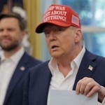 　ロシアのプーチン大統領と一緒に米アラスカ州で撮影された写真を手にするトランプ大統領＝８月２２日、ワシントン（ゲッティ＝共同）