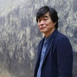 　油絵「一九四六」の前に立つ中国人画家の王希奇さん＝６日午後、福岡市