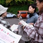 　登山客にヒグマへの注意を呼びかけるチラシを配るＮＰＯのボランティア（右から２人目）＝１０月、札幌市