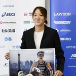 　現役引退の記者会見でパネルを手に写真に納まるトライアスロン女子の高橋侑子＝１１日、東京都新宿区