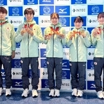 　トランポリンの世界選手権から帰国し、メダルを手に撮影に応じる宮野隼人（左から２人目）、田中沙季（同４人目）ら＝１１日、羽田空港