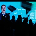 　イラクのスダニ首相が映ったスクリーン前で、選挙結果を喜ぶ支持者＝１２日、バグダッド（ＡＰ＝共同）