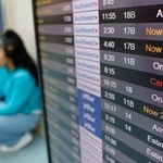 　欠航や遅延などの運航状況を示す米ロサンゼルス国際空港の発着案内板＝１２日（ゲッティ＝共同）