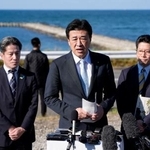 　横田めぐみさんが北朝鮮工作員に拉致されたとみられる現場周辺を視察し、記者団の取材に応じる木原官房長官。めぐみさんの弟拓也さん（右）と哲也さん（左）も同行した＝１５日午後、新潟市