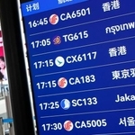 　北京首都国際空港の出発ロビーで羽田空港行きの便が表示された電光掲示板＝１６日（共同）