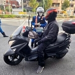 　バイク利用者に交通事故への注意を促す警察官＝１８日午前、東京都江戸川区