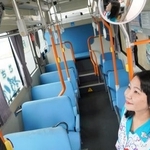 　沖縄県中城村のコミュニティーバスで導入された顔認証システムに顔をかざす比嘉麻乃村長＝１８日午前