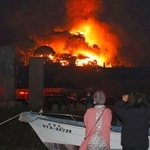 　大分市佐賀関の火災現場を心配そうに見つめる近隣住民＝１８日午後９時４２分