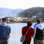 　大分市佐賀関の大規模火災現場を見つめる人たち＝１９日午前９時４１分