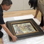 　贋作と判断した油彩画「自転車乗り」を梱包する徳島県立近代美術館の学芸員＝７月、徳島市