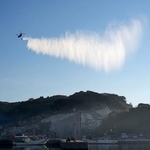 　大分市佐賀関の大規模火災現場付近で上空から放水する自衛隊のヘリコプター＝２０日午前８時４分