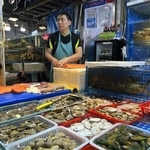 　中国北京市にある海鮮市場の鮮魚店で、水産物を販売する従業員＝６月