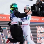 　Ｗ杯ジャンプ女子個人第１戦で２回目の飛躍を終え、伊藤有希と抱き合う丸山希（右）。Ｗ杯初優勝を決めた＝リレハンメル（共同）