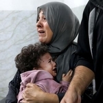 　イスラエル軍の攻撃を受けた後、医療処置を受けたパレスチナ人の母子＝２２日、ガザ（ロイター＝共同）