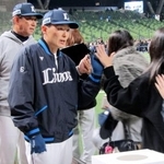 　大分市佐賀関で起きた大規模火災の被害者支援のため、募金活動を行う西武・源田。奥は鳥越ヘッドコーチ＝２３日、ベルーナドーム