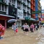 　冠水したエリアを歩く観光客ら＝２３日、タイ・ソンクラー県ハジャイ（ロイター＝共同）