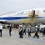 　整備中の航空機を見学する小学生ら＝２５日、台湾・桃園市（共同）