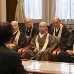 　京都市の松井孝治市長（手前）と面会する京都仏教会の宮城泰年常務理事（右から３人目）ら＝２５日午後、京都市役所