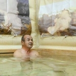 　避難先の市民センターに設置された入浴施設で、湯船に漬かる被災者＝２５日午後、大分市佐賀関