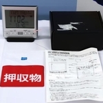 　デジタル時計型の小型カメラ（左上）などの押収物＝２７日午前、愛知県警本部