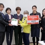 　スポーツ庁の担当者（左端）に「歯止め規定」撤廃を求める署名を手渡す団体のメンバーら＝２７日午後、文科省