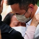 　安否不明者の確認所から出た直後、泣き崩れる人＝２７日、香港（共同）