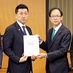　赤間二郎防災担当相（左）に要望書を手渡す大分県の佐藤樹一郎知事＝２７日午後、内閣府