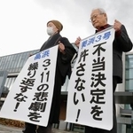 　関西電力美浜原発３号機と高浜１～４号機の運転差し止めを求めた仮処分の即時抗告審で、申し立てが退けられ「不当決定」などと書いた紙を掲げる原告ら＝２８日午前、名古屋高裁金沢支部前