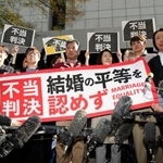 　同性カップルら８人が国に損害賠償を求めた東京第２次訴訟の控訴審判決を受け「不当判決」などと書かれた紙を掲げる原告ら＝２８日午前、東京高裁