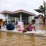 　２９日、スリランカ・コロンボで、冠水した道路を進む人たち（ＡＰ＝共同）
